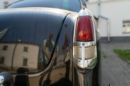 Russia, Valaam Island, July 27, 2024 - GAZ 21, Volga, black vintage car tail light gleams brightly in sunlightのeditorial素材