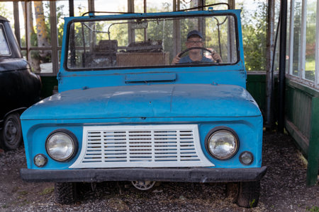 Pskov Region, Russia , July 21, 2024 - vintage blue vehicle sits stationary in a rustic shed, LUAZのeditorial素材