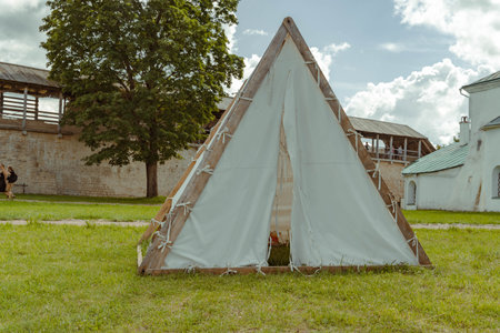 Pskov Region, Russia , Izborsk, July 21, 2024 - A teepee stands under a tree in a well-kept outdoor spaceのeditorial素材