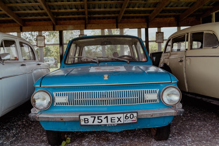 Pskov Region, Russia , July 21, 2024 - classic blue automobile showcased under a wooden structure, zaz 966のeditorial素材