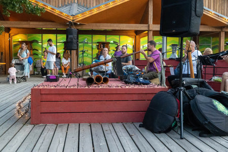 Russia, Sosnovy Bor, September 7, 2024 - Musicians play lively tunes while an audience enjoys a summer eveningのeditorial素材