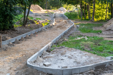 A winding pathway is being constructed with concrete curbing.の写真素材