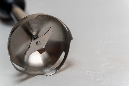 Stainless steel blender attachment resting on a light surfaceの写真素材