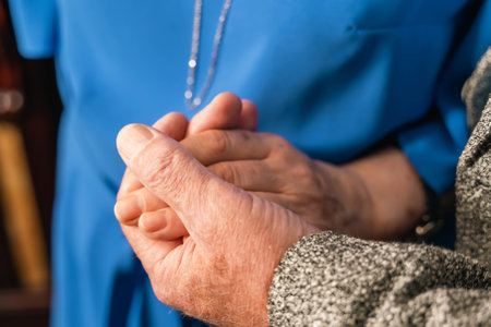 Elderly couple holding hands showing love and supportの写真素材
