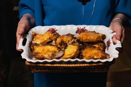 Woman holding french meat with melted cheese in white dishの写真素材