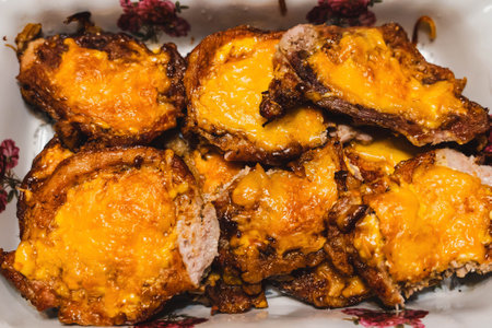 Delicious roasted pork chops with melted cheddar cheese in baking dishの写真素材