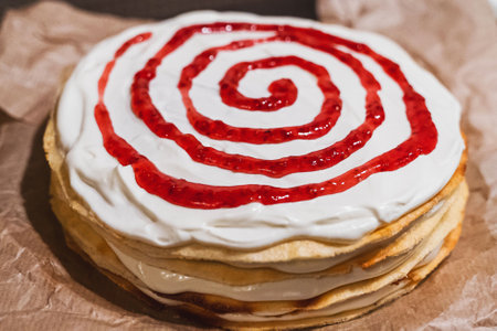 Delicious crepe cake decorated with whipped cream and strawberry sauceの写真素材