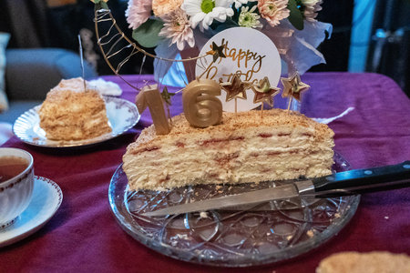 Sixteenth birthday cake showing layers with knife and happy birthday sign