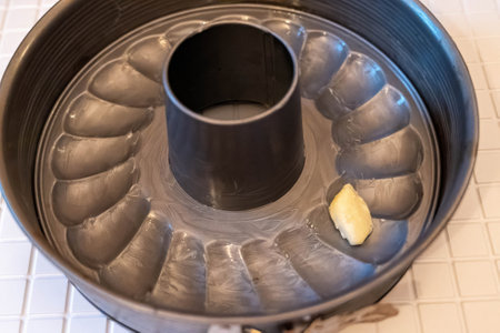 Greasing a bundt pan with butter, preparing to bake a delicious cakeの写真素材