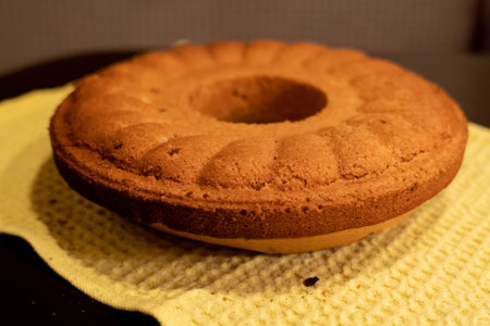 Ring cake cooling on a yellow kitchen cloth after being bakedの写真素材