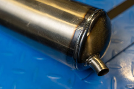 Close-up of a welded metal cylinder on a blue metal surface, highlighting its construction and industrial aestheticの写真素材