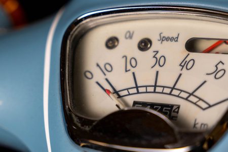 Close-up of a vintage scooter's speedometer indicating a low speed and oil level, highlighting the classic design and functionality of the vehicleの写真素材