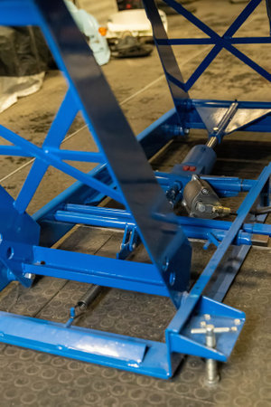 Close-up of a blue hydraulic scissor lift table, highlighting its mechanical components and robust constructionの写真素材