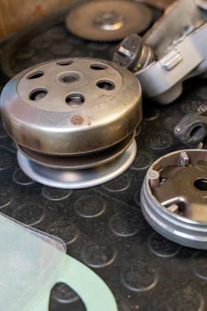 Scooter cvt transmission parts lying on a workbench during maintenance, close-upの写真素材