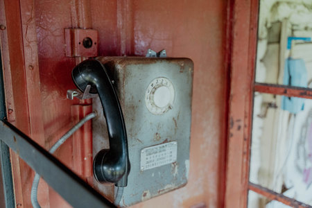 An antique payphone stands ready for use in a quiet booth.