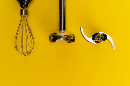 Kitchen utensils arranged neatly on a vibrant yellow surface.の写真素材