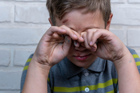 A person covers their eyes with their hands while appearing distressedの写真素材
