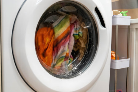 Washing machine washing colorful clothes at home laundry roomの写真素材