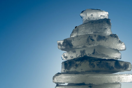 Stack of ice blocks creating a tower against blue skyの写真素材