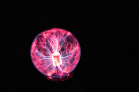 Plasma ball glowing with pink and purple static electricity in the darkの写真素材