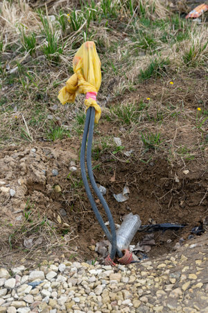 Electrical cables emerging from the ground covered with plastic bagの写真素材