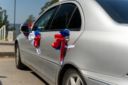 Silver car decorated with red white and blue ribbons for wedding celebrationの写真素材