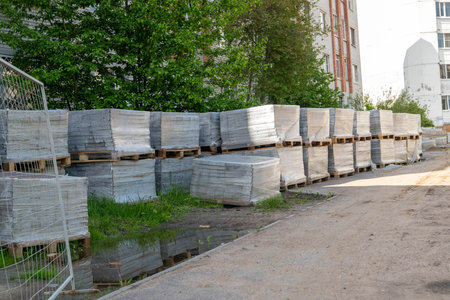 Stacks of paving stone tiles on wooden pallets at construction siteの写真素材