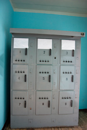 Electrical cabinet showing fuses and switches in room with turquoise wall