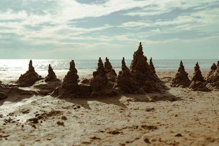 Sandcastle kingdom rising on sunny beach: majestic sand structures by the sea