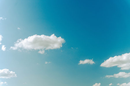 White clouds drifting across vibrant blue sky on sunny day