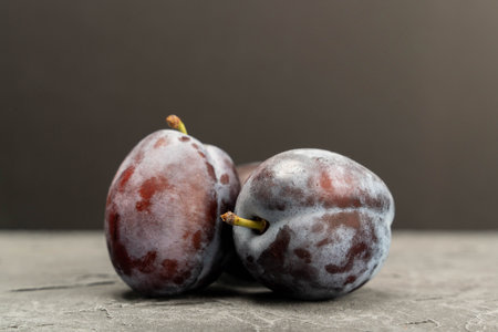 Ripe blue plums with natural bloom on grey background, fresh fruitの写真素材
