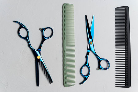 Hairdressing tools laying on light grey surface