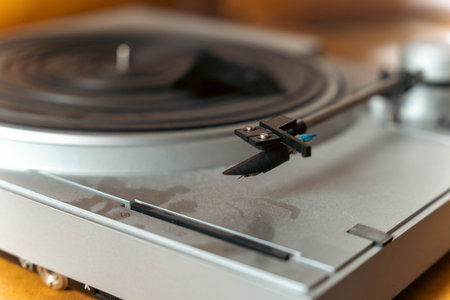 Close-up of a vintage turntable with a stylus arm positioned above a vinyl record, showcasing the intricate details of the audio equipment and its nostalgic charmの写真素材