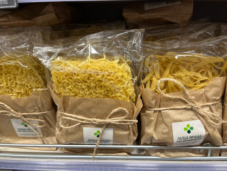 Russia, Sosnovy Bor, October 12, 2025 -Various types of pasta are displayed in clear bags on a store shelfのeditorial素材