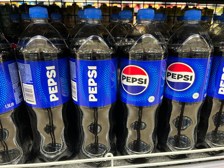 Russia, Sosnovy Bor, October 12, 2025 -Shelves filled with bottles of a popular soft drink variety for saleのeditorial素材