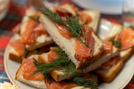 Slices of bread topped with salmon and herbs on a plate during dinner