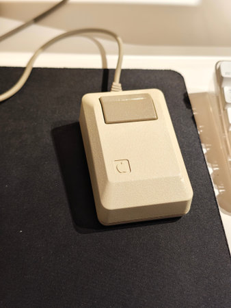 Russia, St. Petersburg, March 14, 2026 -Old computer mouse placed on a black mousepad near a...