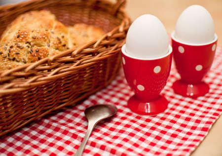 Hard Boiled Eggs and Rolls in Basket on Tableの写真素材