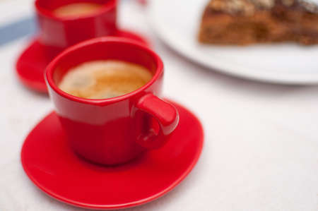 Espresso in Red Cup With Chocolate Cake on Plateの写真素材