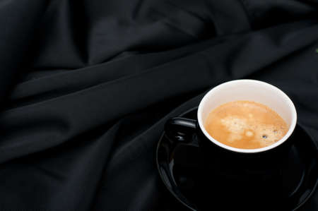 Cup of Espresso Coffee on Black Silky Draperyの写真素材