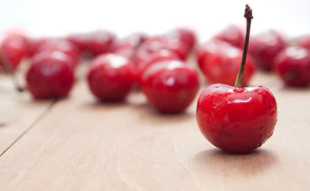 Fresh Red Cherries on Aged Wooden Table - Shallow Depth of Fieldの写真素材