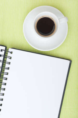 Closeup of Blank Diary and Cup of Coffee on Tableの写真素材