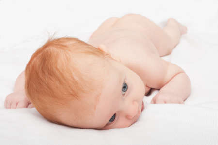 Cute Naked Red Haired Baby Lying on Frontの写真素材