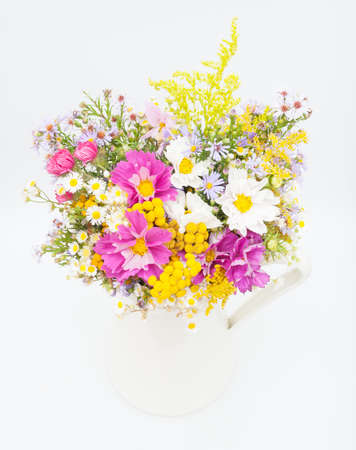 Bouquet of Wild Summer Flowers in White Pitcher on White Backgroundの写真素材
