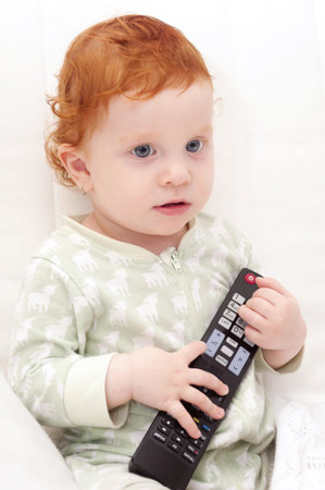 Toddler Baby Watching TV Holding Remote Controlの写真素材