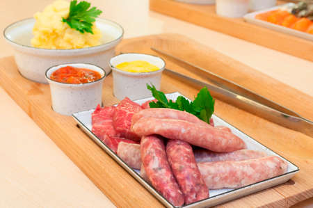 Barbecue - Sausages, Raw Meat, Sauces and Mashed Potatoes on the tableの写真素材