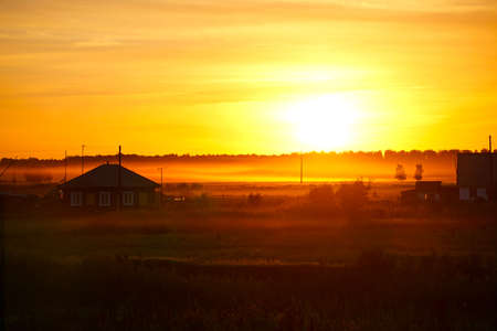 Outskirts of a Russian Siberian village at sunset with fogの写真素材
