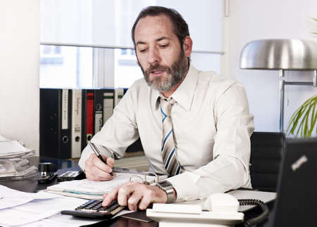 Mature businessman calculating finance. Horizontal shotの写真素材