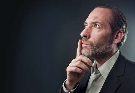 Studio shot of businessman in a deep thought over colored background (shot on PhaseOne 45)の写真素材