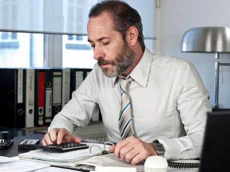 Mature businessman calculating finance  Horizontal shotの写真素材